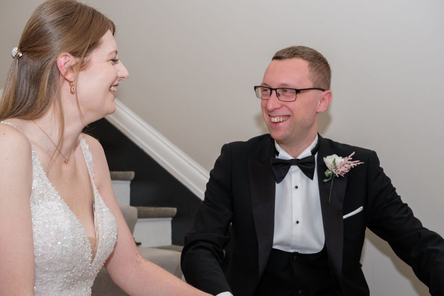 A couple in formal wedding attire sits together at a table during a special celebration.