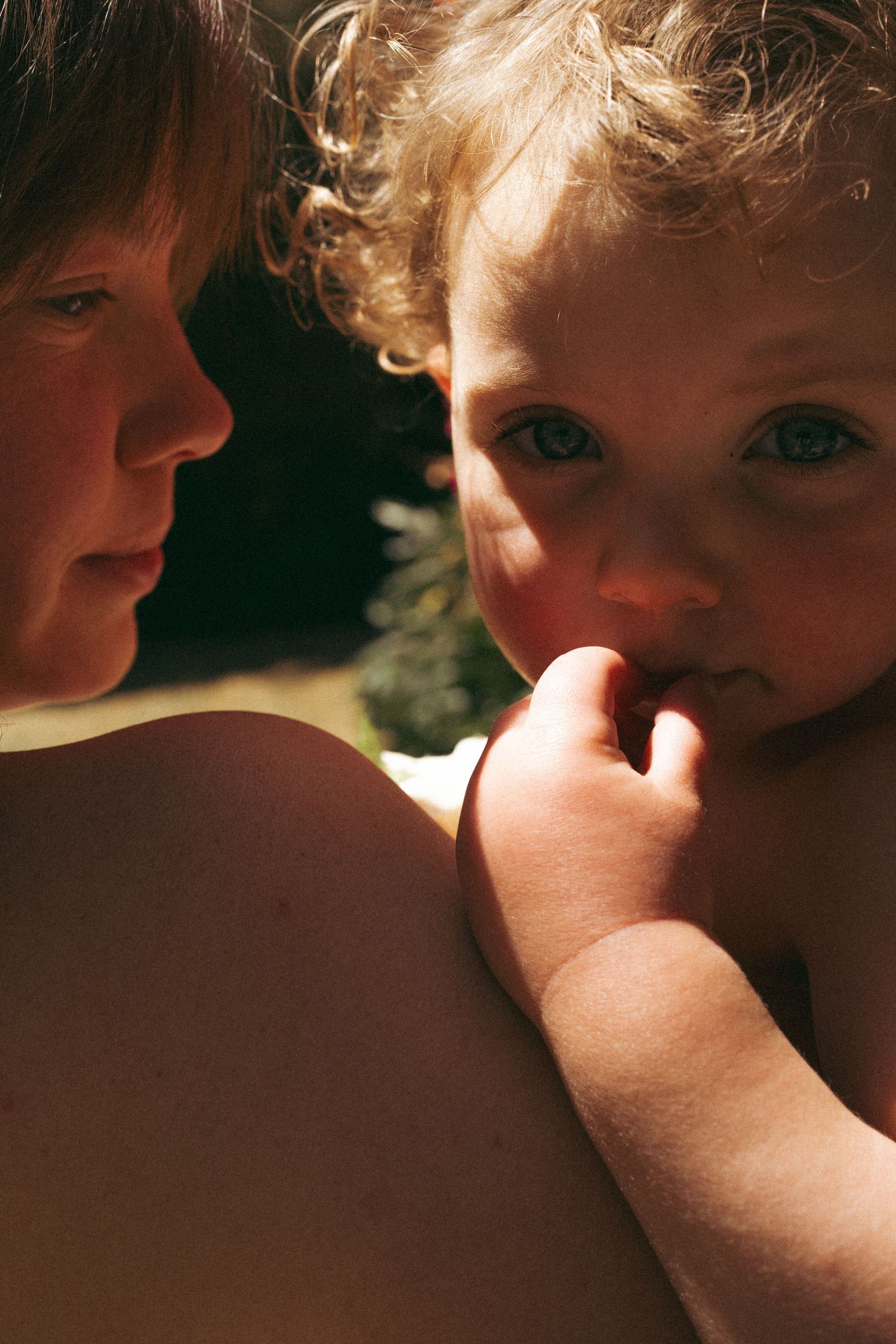 Close-up artistic portrait showing a child's face in dramatic lighting.