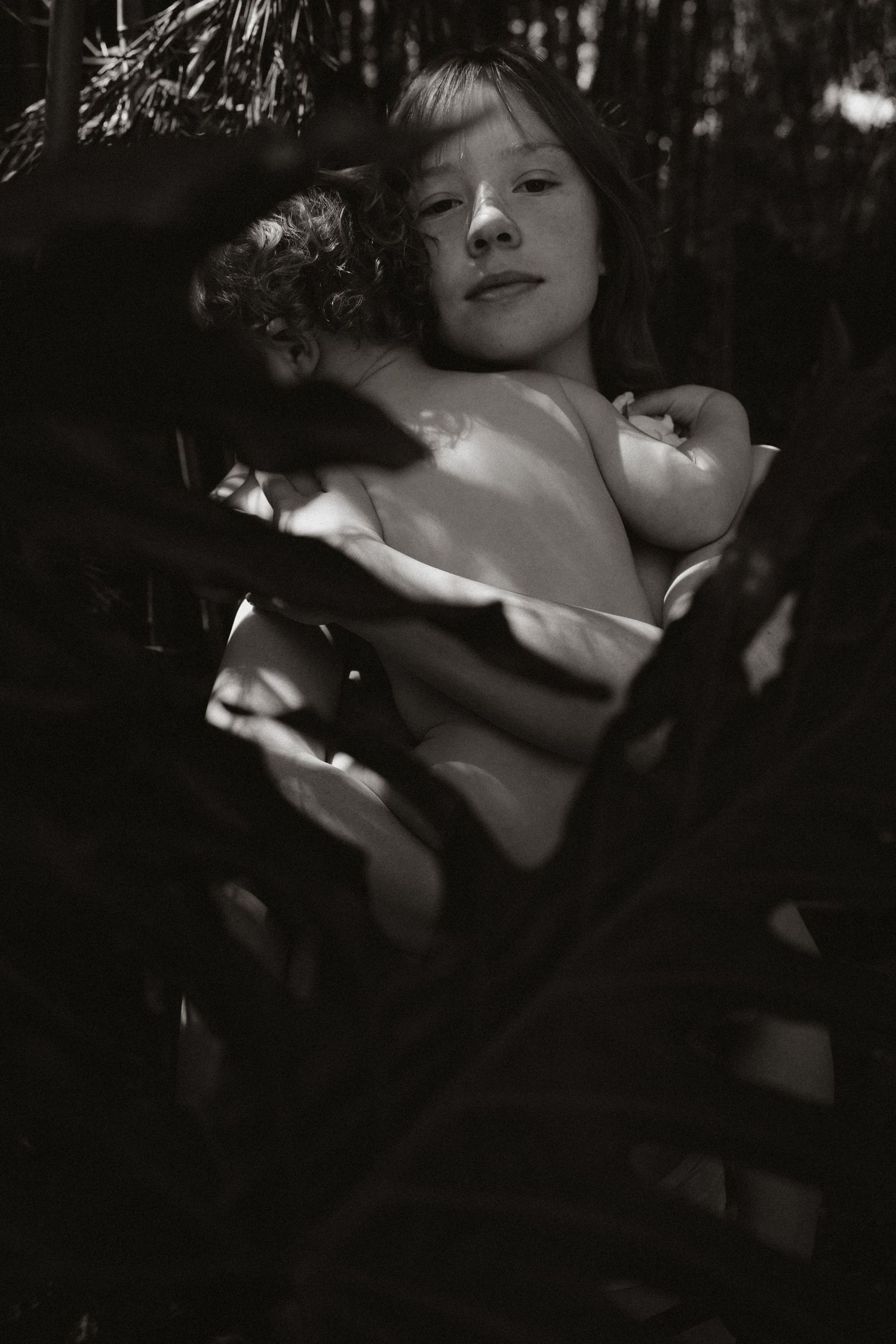 Artistic black and white portrait series showing dramatic shadows and light falling across a figure's face.