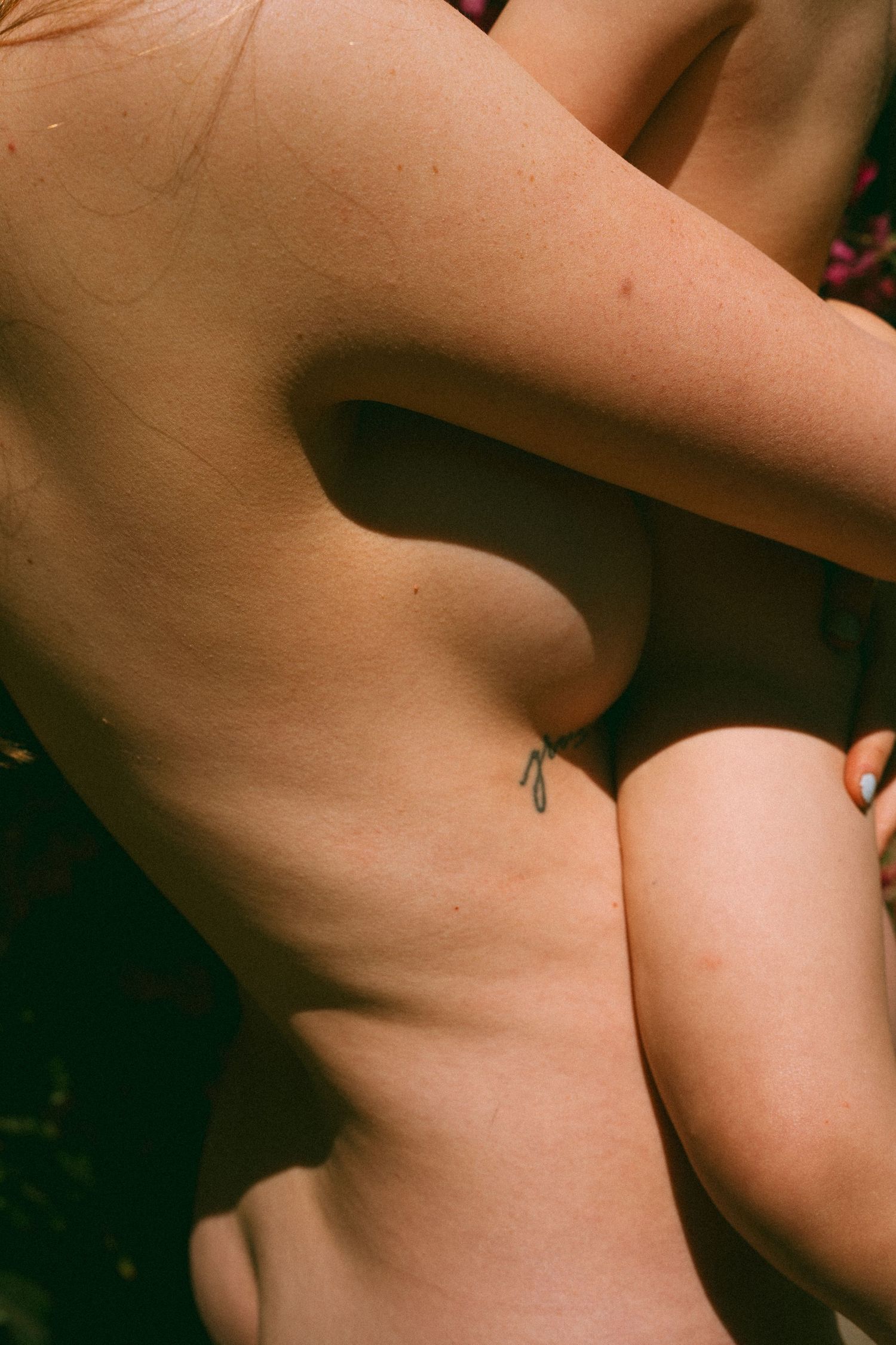intimate close up of a mother and her baby, emphasising the natural curves of their bodies together