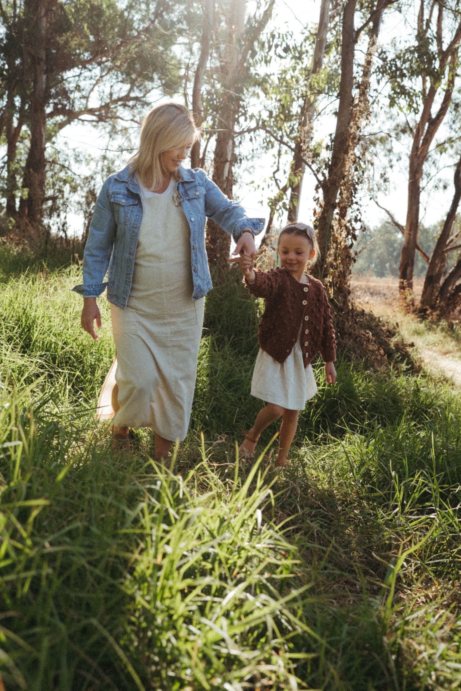 Sun-dappled scenes among tall grass and eucalyptus trees with people in casual wear.