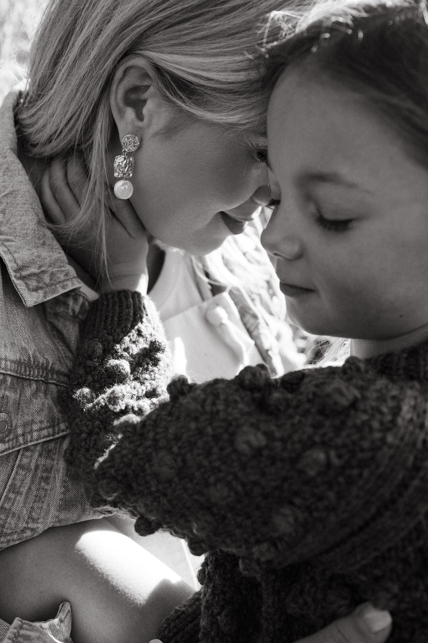 A black and white photo shows two people in profile sharing an intimate moment.
