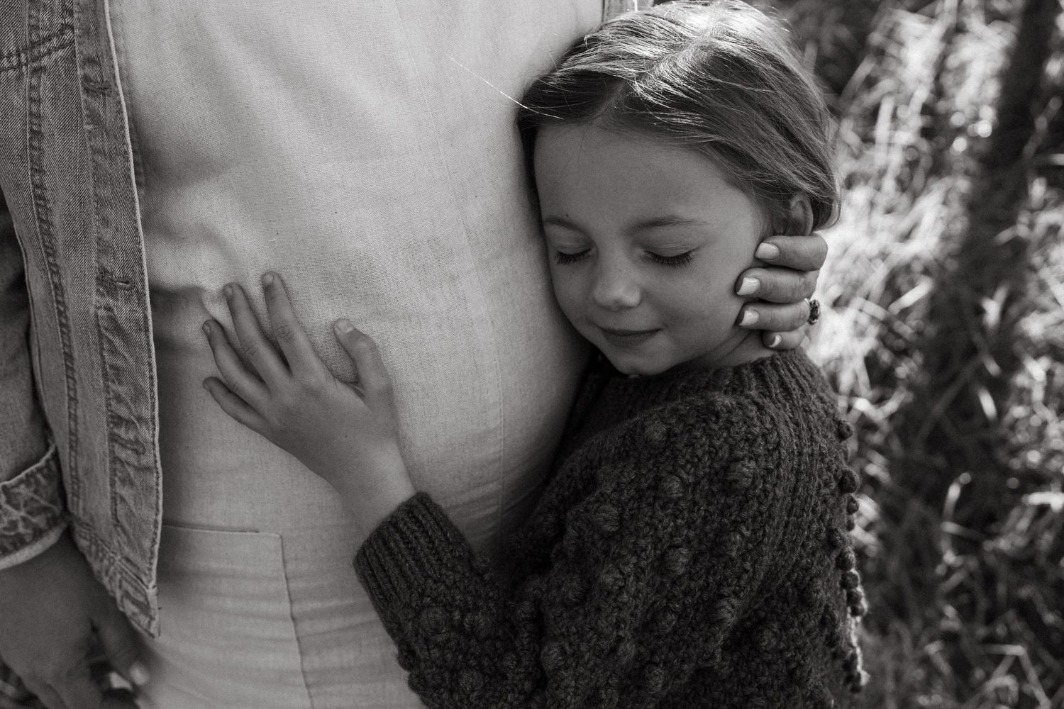A tender black and white photograph showing a gentle embrace against white clothing.