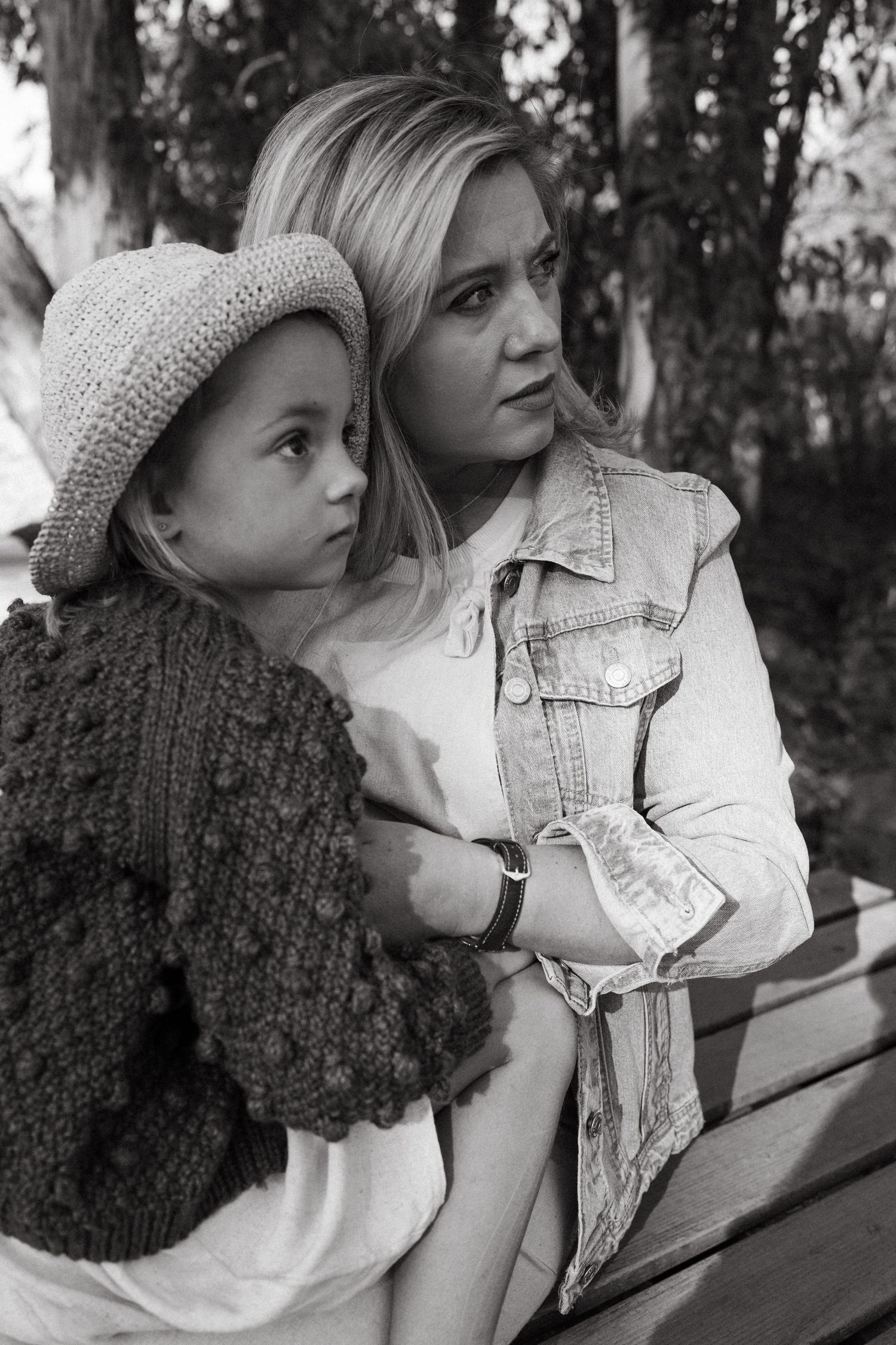 Black and white portrait series showing tender moments between two people on a park bench.