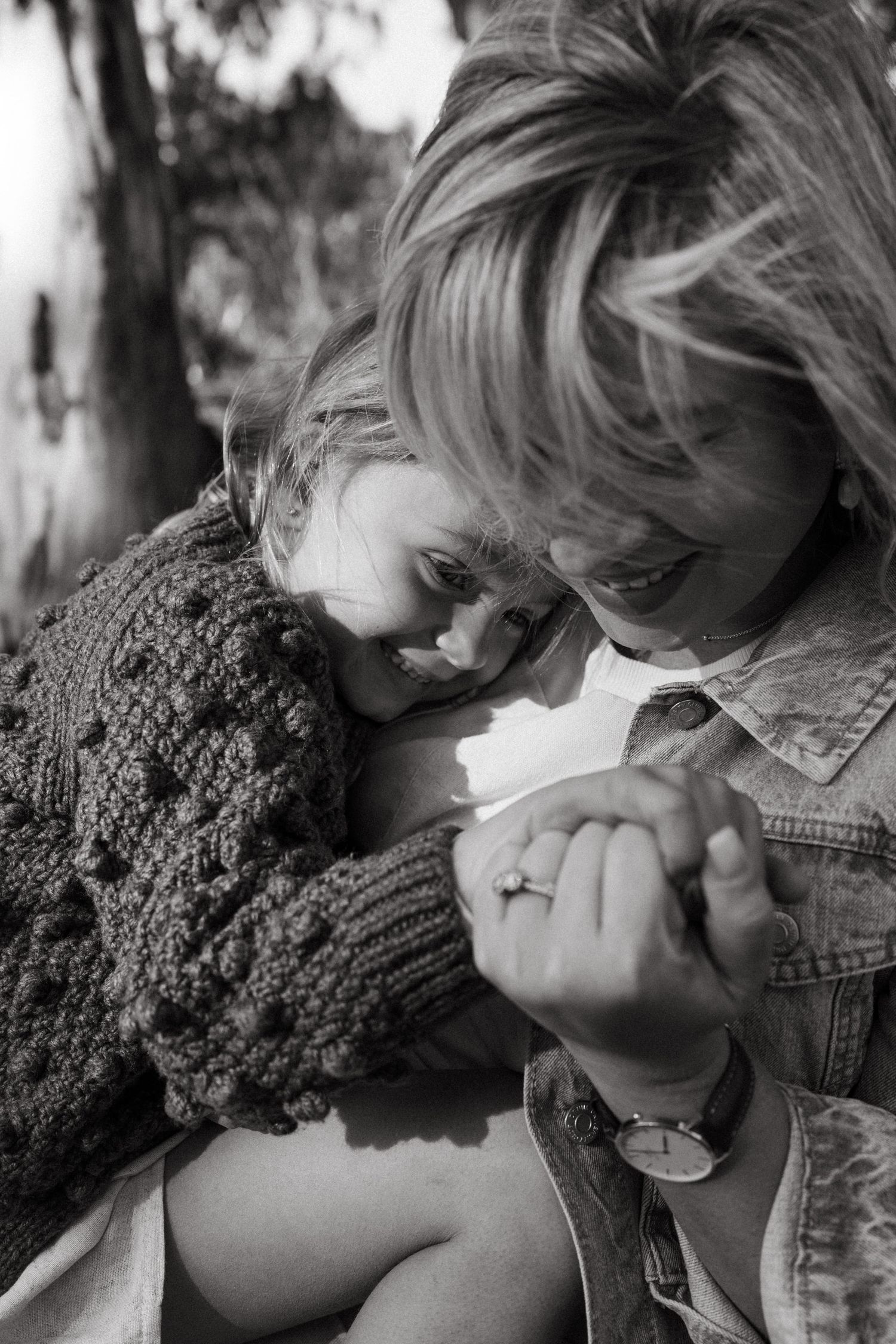 Black and white series capturing emotional moments between two people on a park bench.