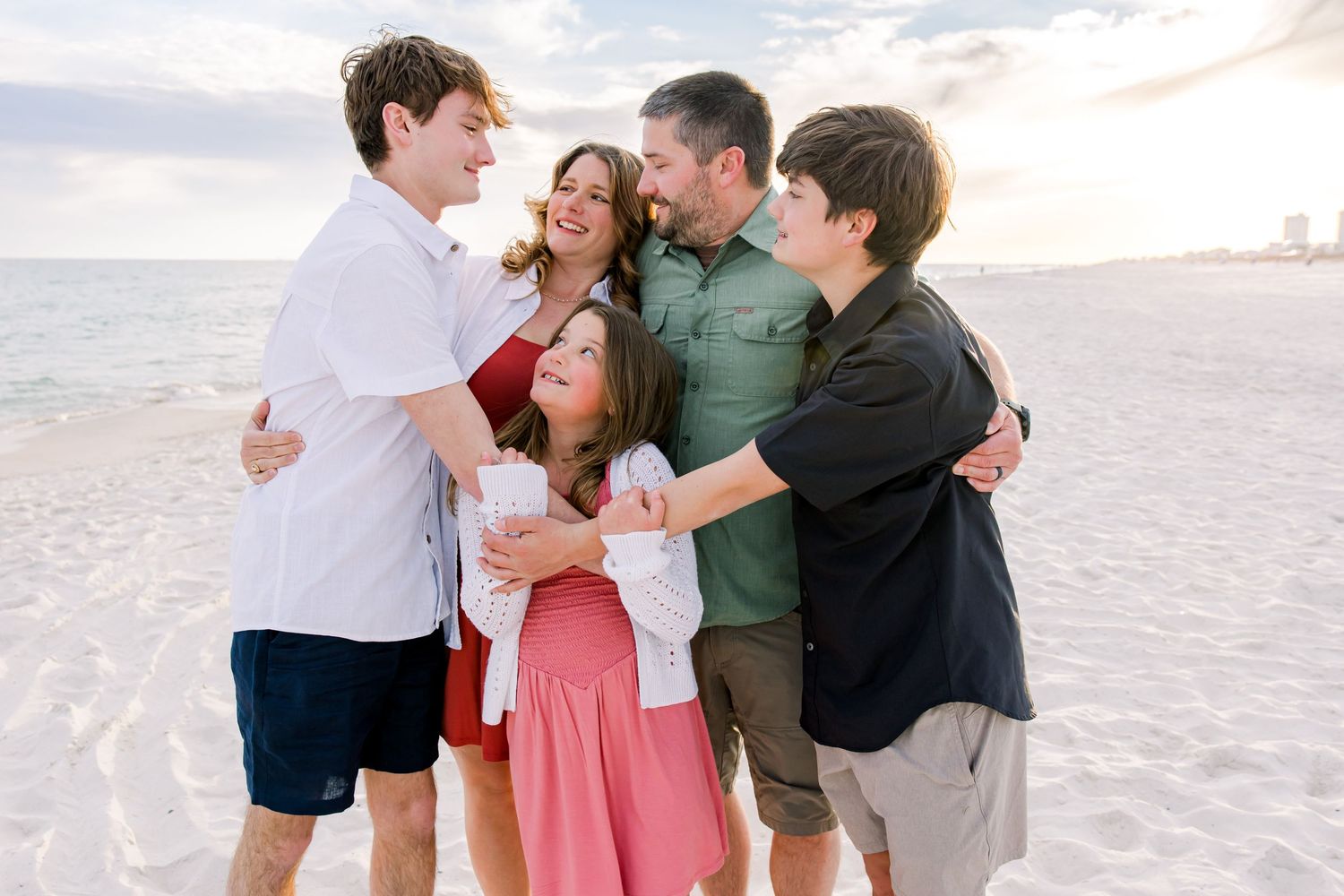 Family laughing together during beach photography session on the alabama gulf coast.