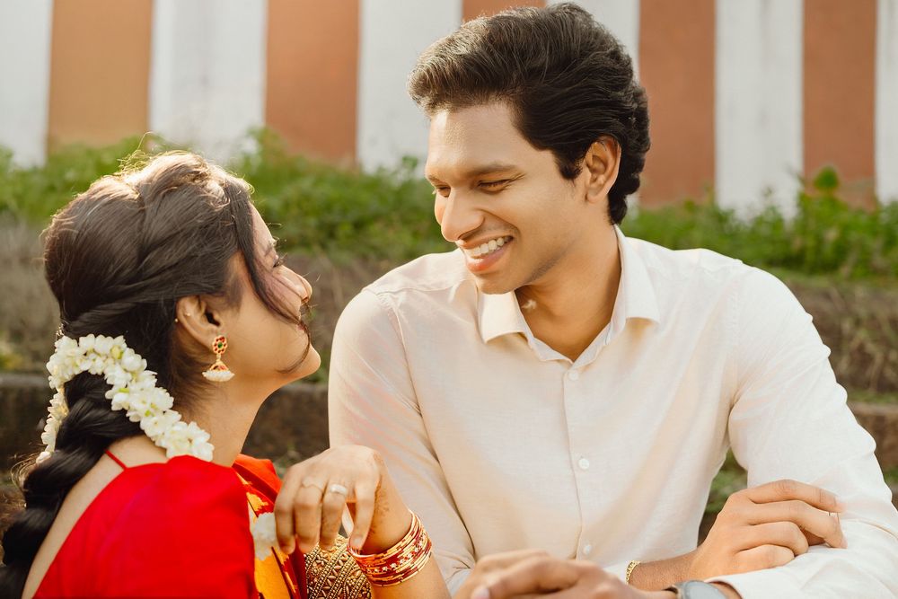 Candid moments captured of couple in traditional Indian attire during outdoor photoshoot.