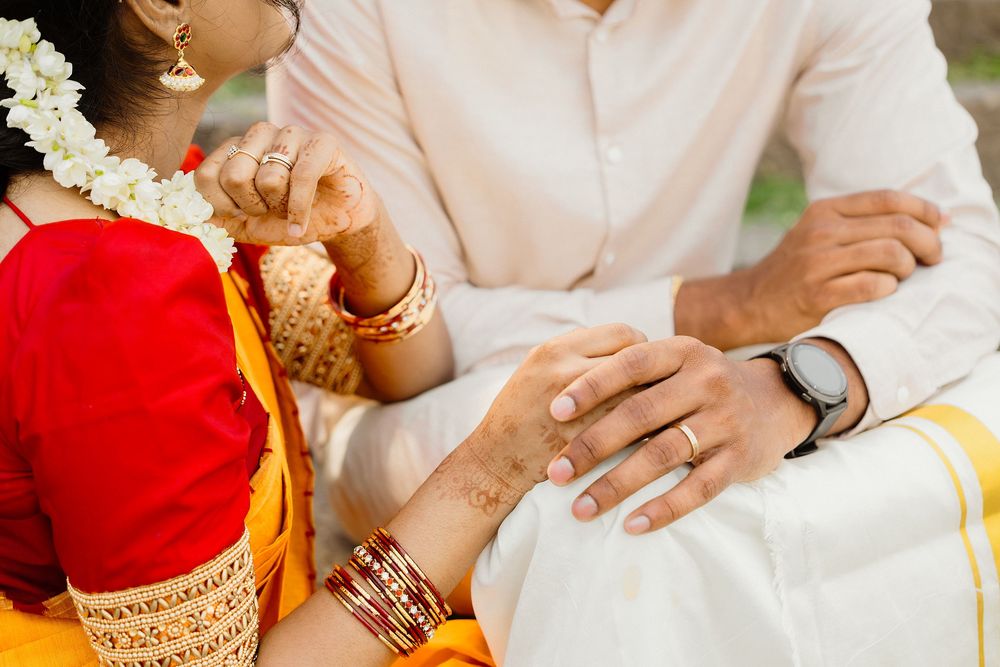 Close-up of hands with traditional Indian wedding jewelry and henna designs.