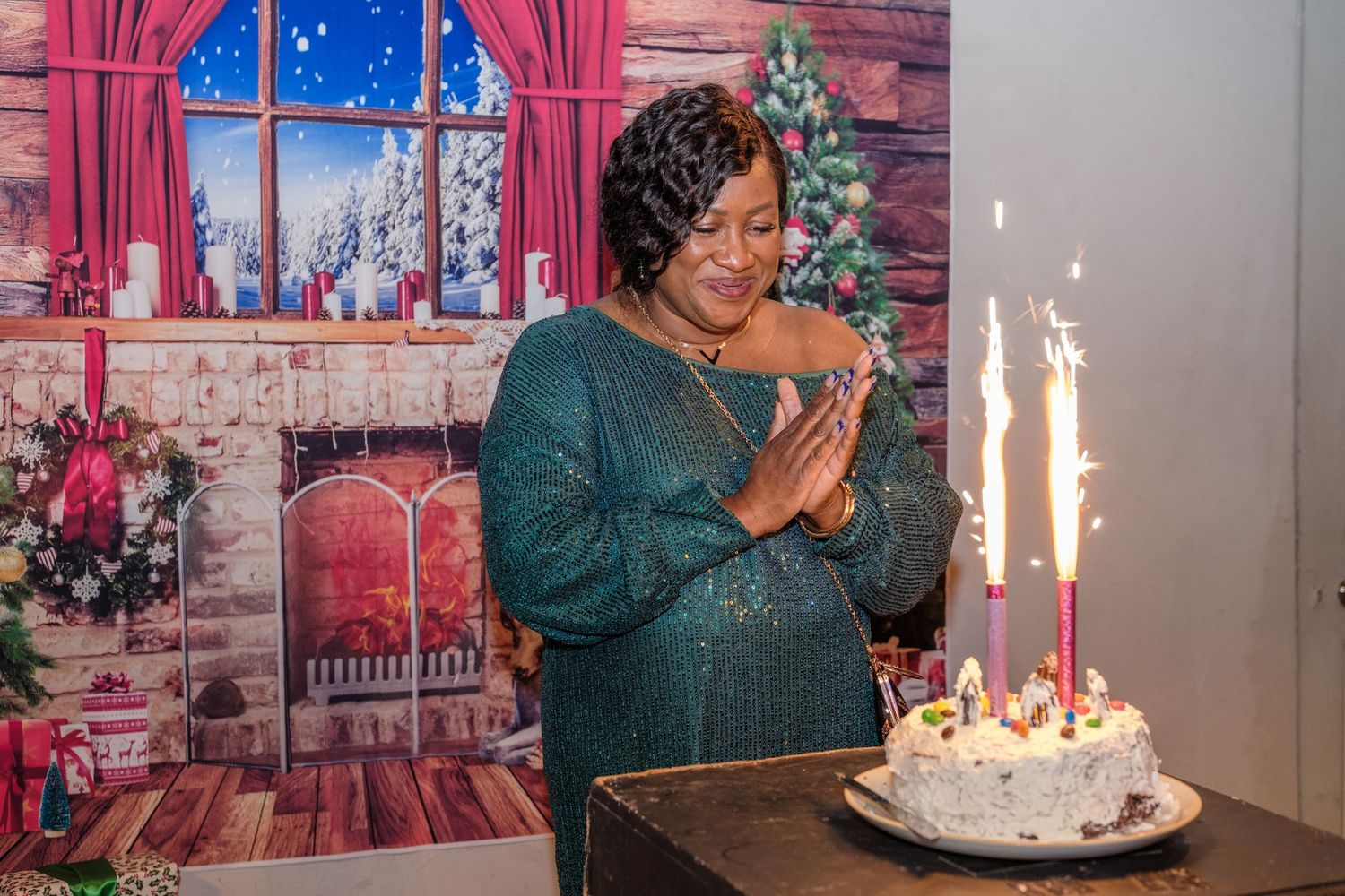 A festive birthday celebration scene with pink curtains, Christmas decorations, and a glowing white birthday cake.