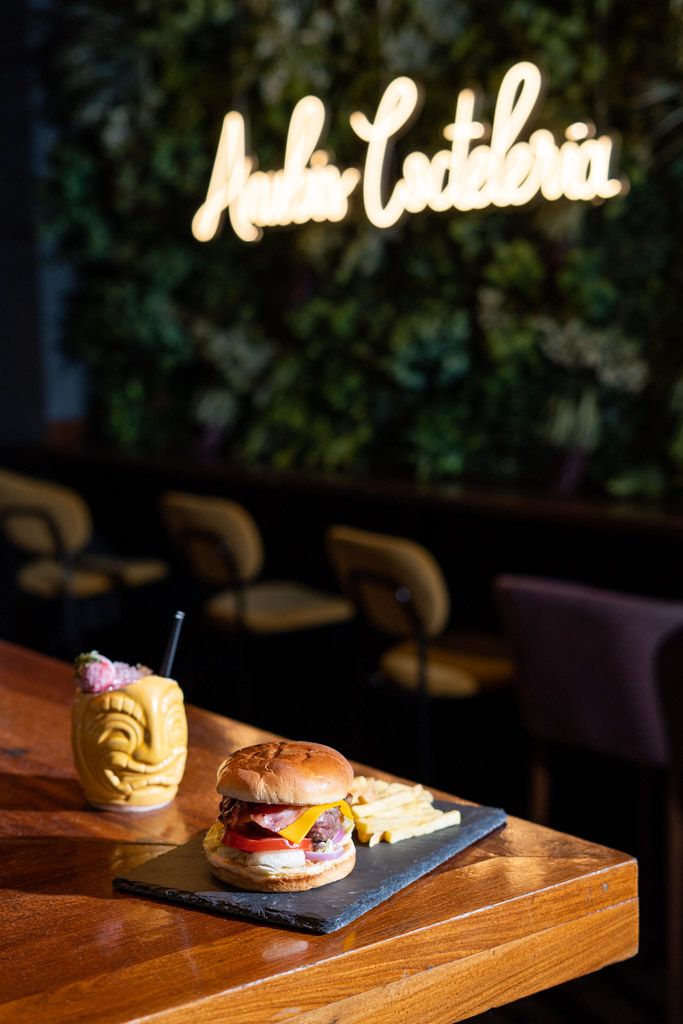 Hamburguesa gourmet presentada sobre mesa de madera en restaurante