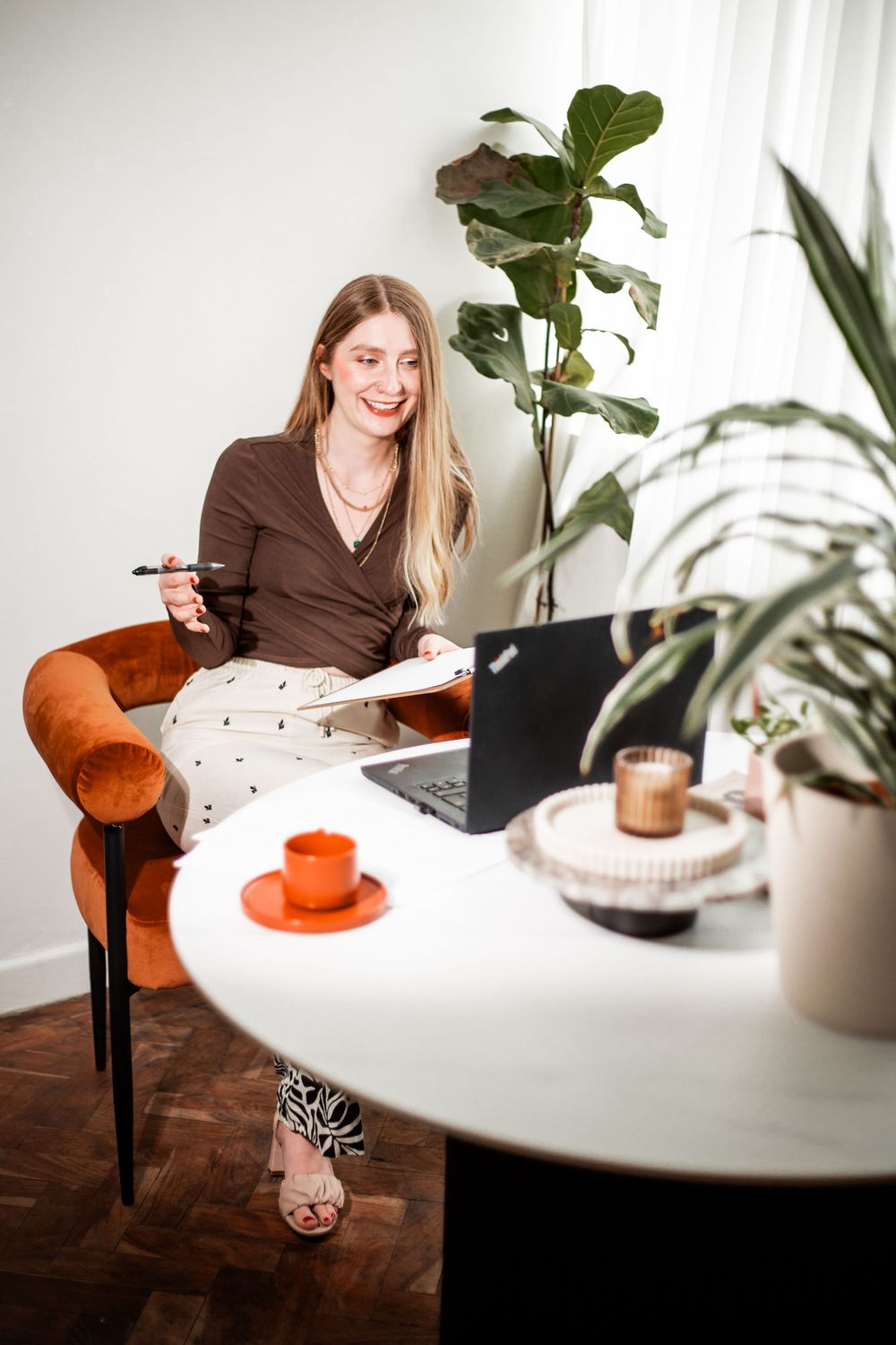 Workspace setting with white table, laptop, and decorative plants.Hypnotherapy at Huddle Studio Plymouth