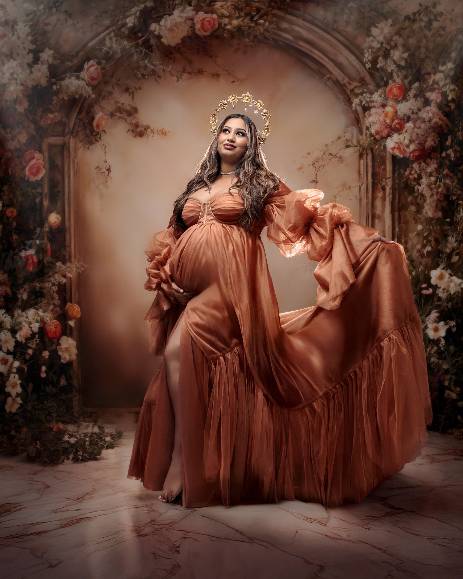 Sydney maternity fine art photography: mum in a shiny bronze couture gown and gold orange flower crown against amber hued floral arch.