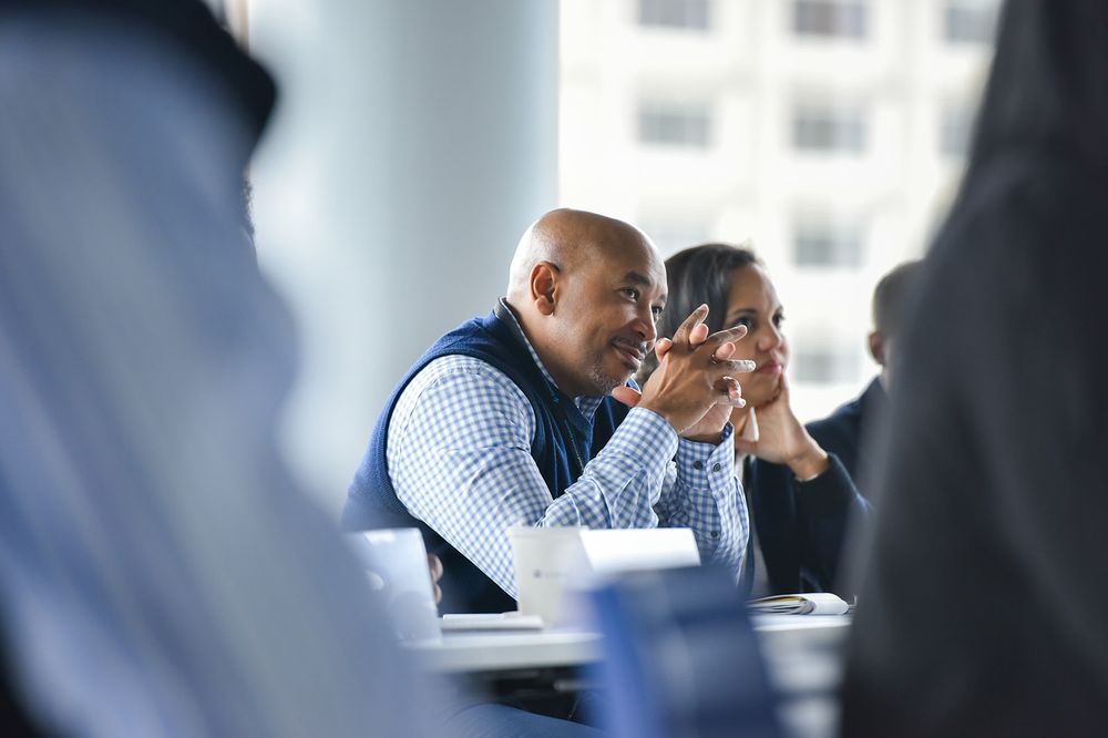 Business professionals engaged in focused discussion during a meeting at conference table.