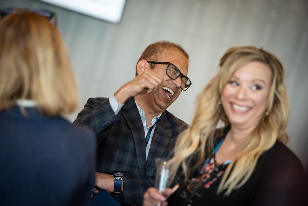 Business professionals sharing a light moment during an informal meeting in an office setting.