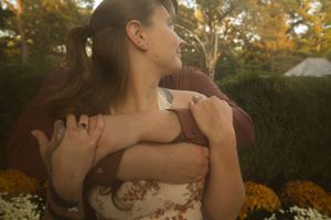 Romantic autumn photoshoot with couple embracing outdoors at golden hour.