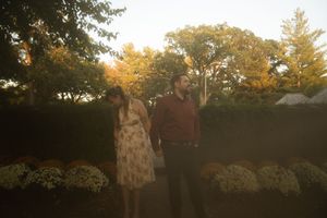 A romantic outdoor photo session in a garden with autumn trees creating a warm golden backdrop.