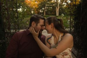 A tender moment captured between a couple in a wooded area during golden hour.
