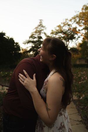 A joyful outdoor photoshoot with natural lighting and autumn trees in the background.