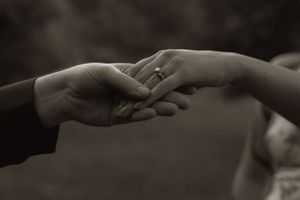 Artistic black and white photo of hands touching tenderly.