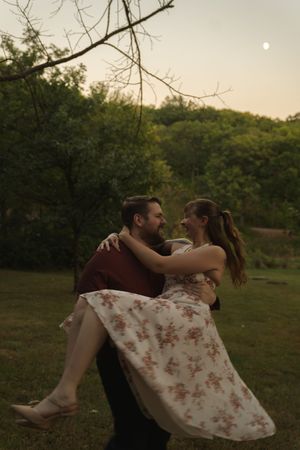 Romantic dance dip in a floral dress at sunset in a meadow.