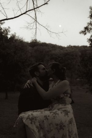 Couple sharing an intimate moment in a natural outdoor setting at dusk.