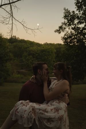 Couple sharing romantic moment in field with sunset glow.