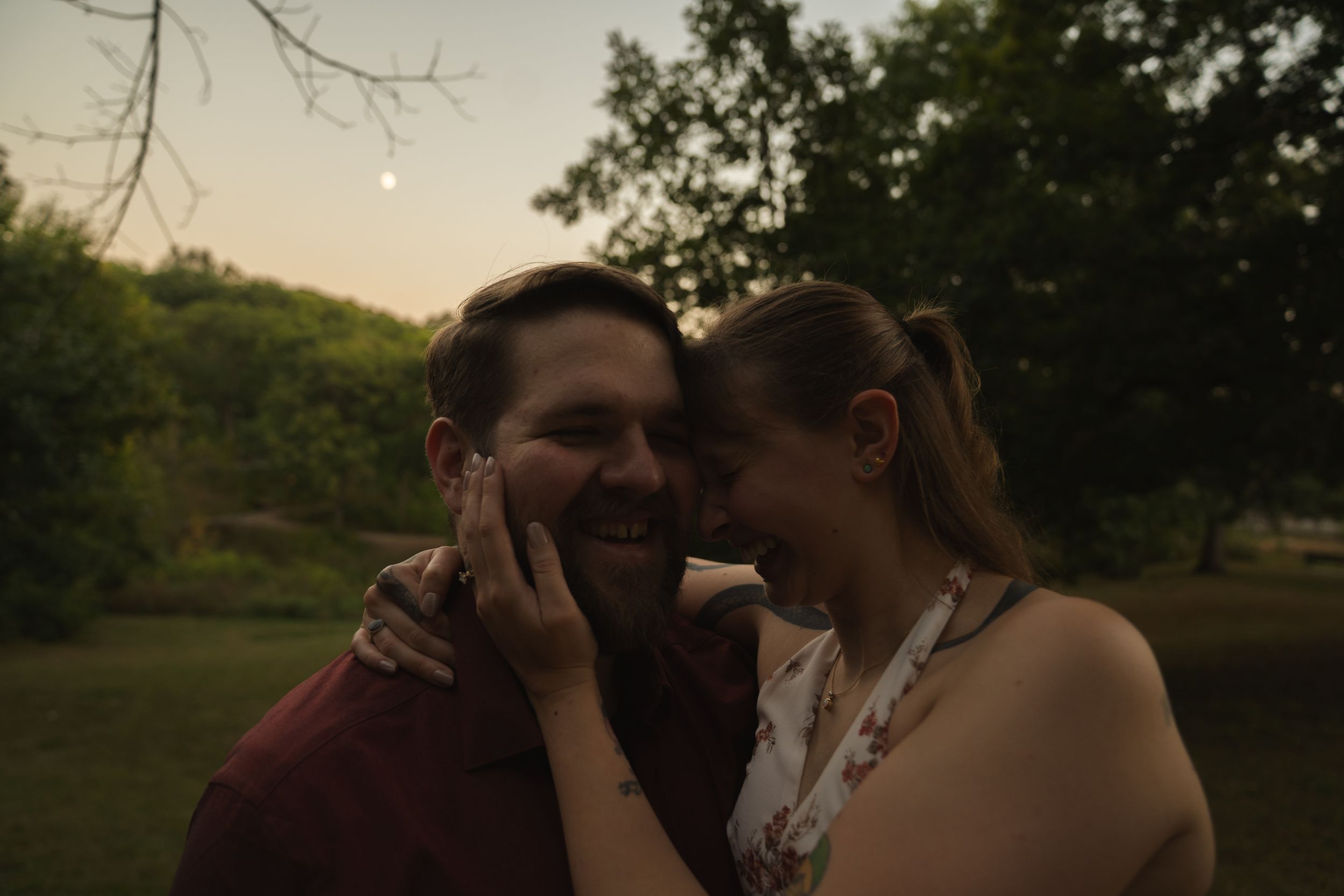 Romantic sunset portrait with trees and water in background.