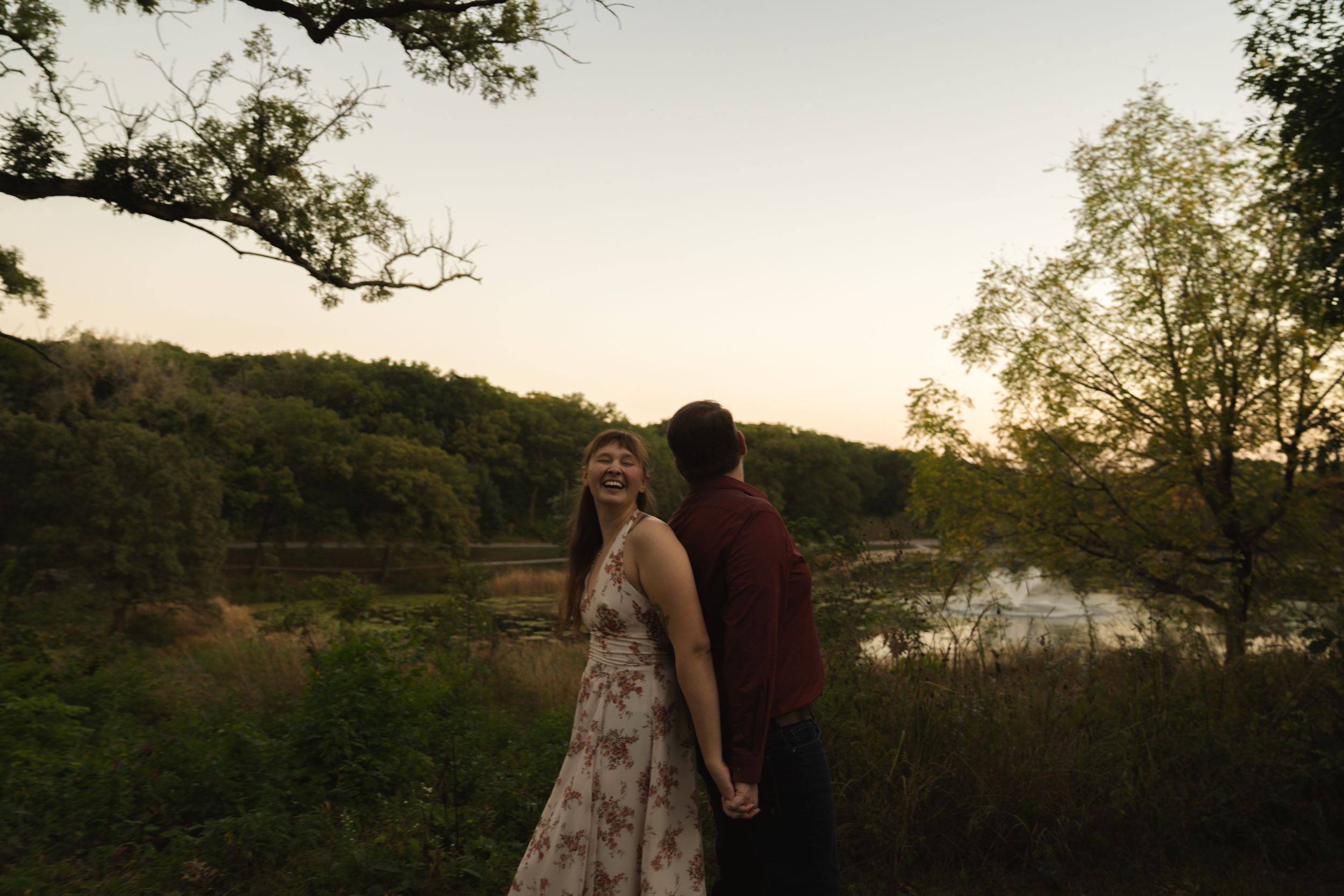 Couple photographed against scenic natural backdrop during sunset.