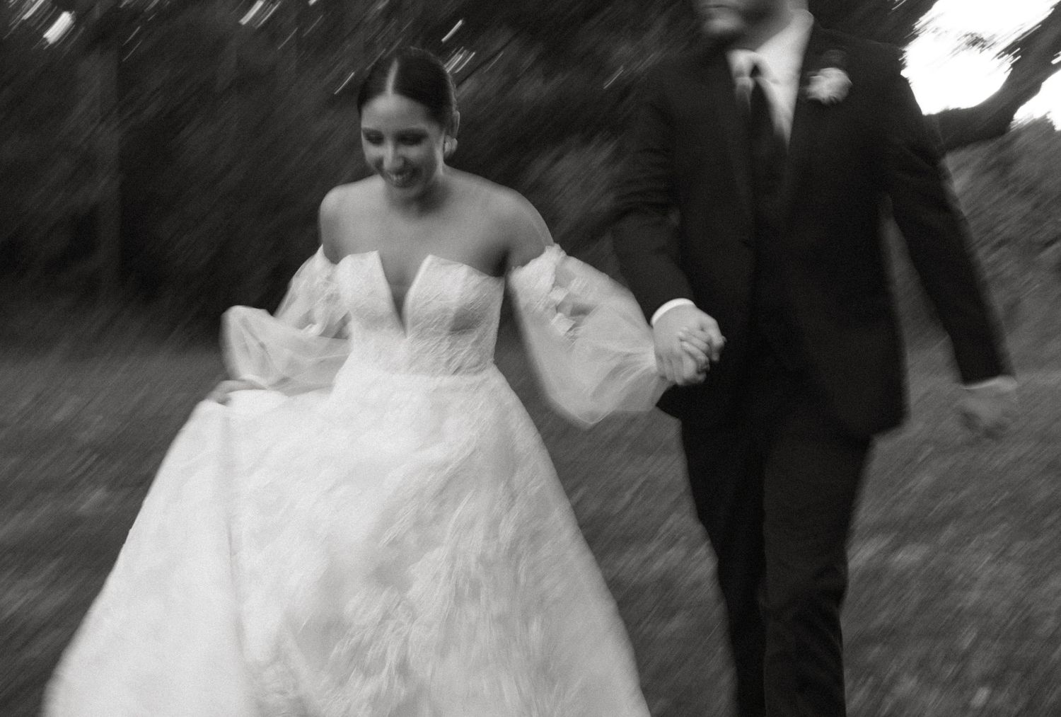 Wedding party members in formal attire walking outdoors on a sunny day.