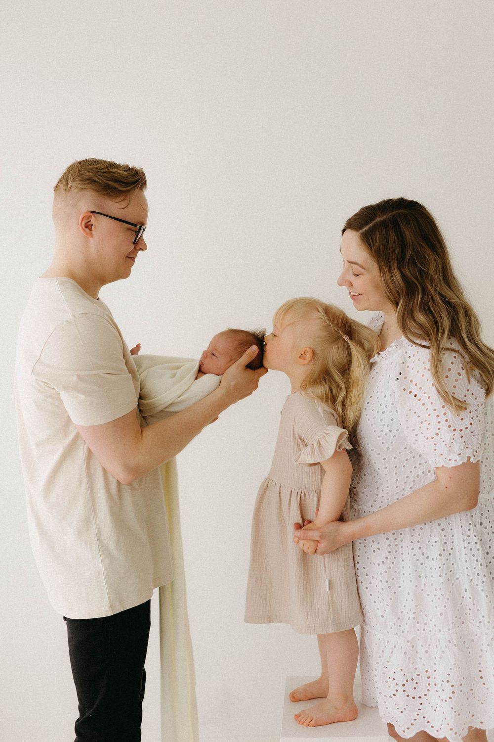 A series of minimalist family photos against a white background showing tender moments between parents and child.