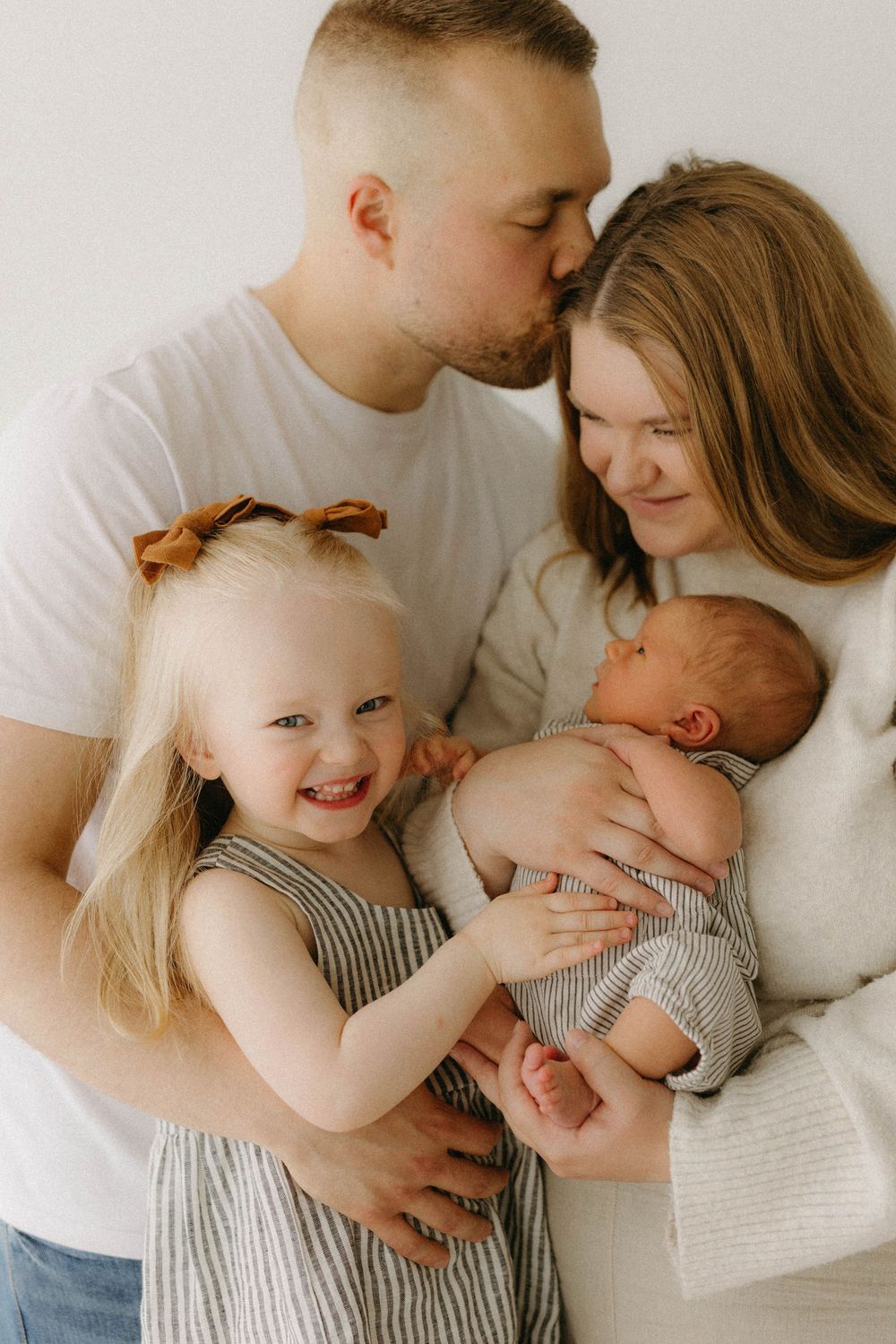 Newbornkuvaus Oulussa, vanhemmat ja sisarus ihastelevat vauvaa.
