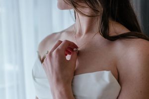 Close up details of white wedding gown bodice and neckline.