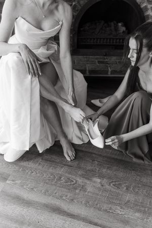 A series of black and white photos showing feet and hands near a wooden floor.