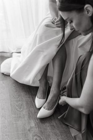 Close-up sequence showing white bridal shoes being put on before a wedding ceremony.