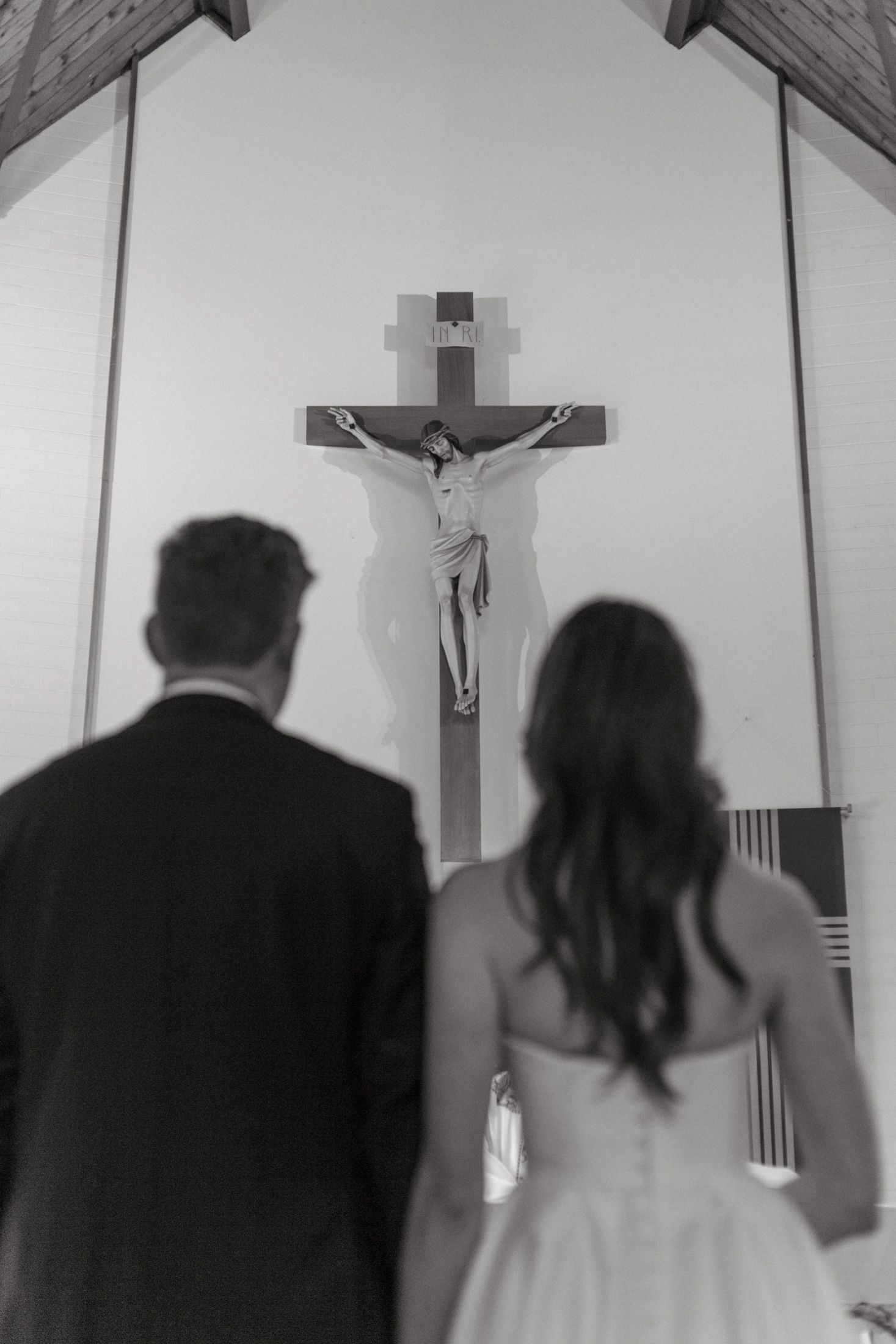 A series of black and white photos showing a couple praying together in a church during a wedding ceremony.