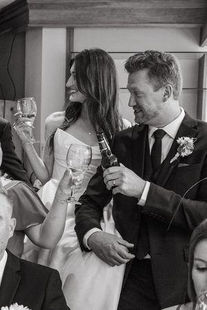 Black and white sequence of a couple toasting with wine glasses at a formal event.