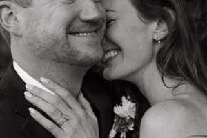 A black and white close-up of a tender romantic moment between newlyweds.