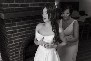 A series of black and white wedding preparation photos showing dress adjustments and intimate getting ready moments.