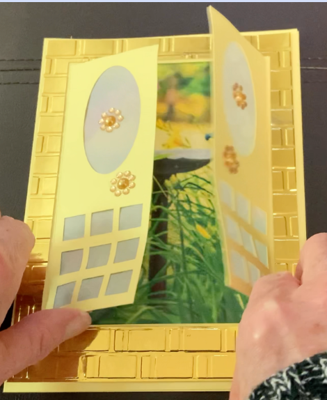 Gate card is partially opened show a view of a garden with bird bath