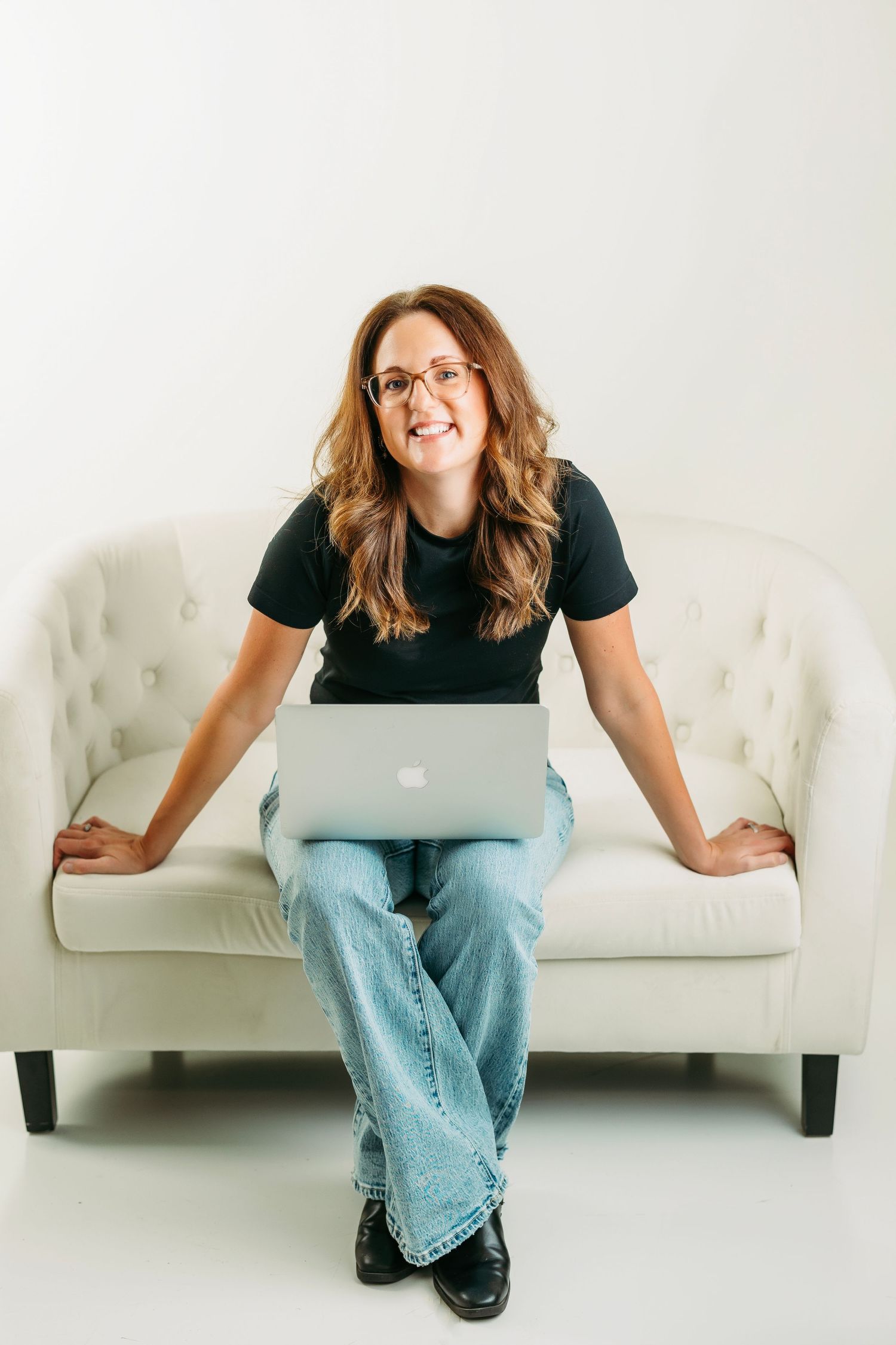 Professional working at a wooden desk with laptop and indoor plants in a bright home office setting.