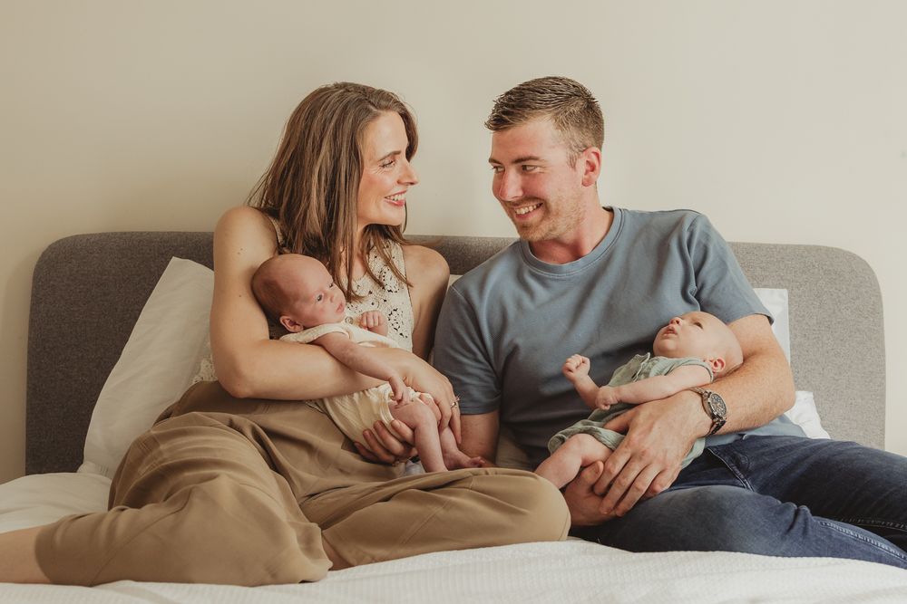Candid family moments with newborn baby on living room couch.