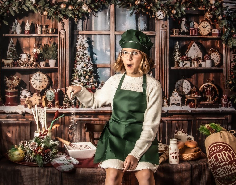A festive holiday scene with someone in a green dress and cream sweater sitting among vintage Christmas decorations.