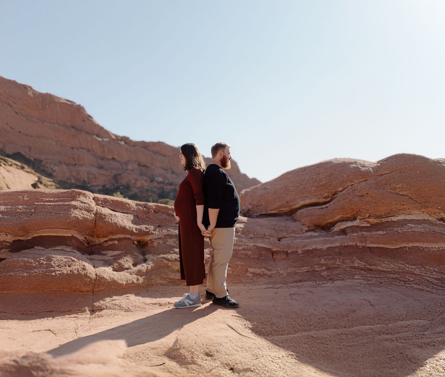 People explore the scenic red rock formations and sandstone cliffs in a desert landscape.