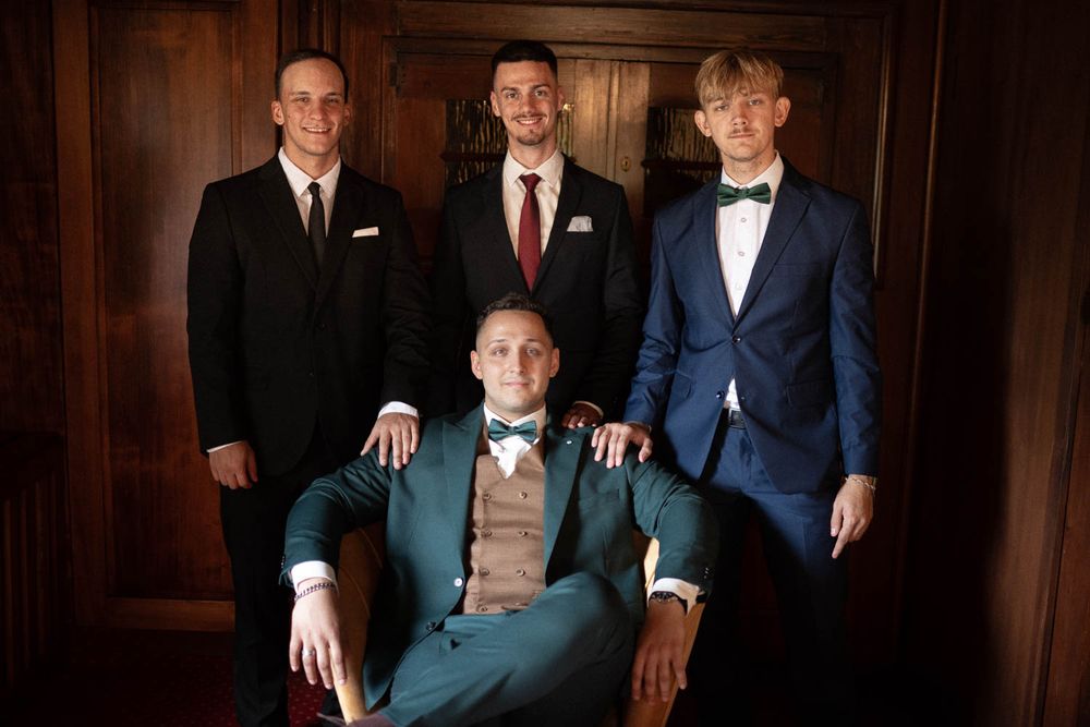 Ženich Jakub s muži ve slavnostních oblecích během svatebních příprav – Hotel & Garden U Holubů - Čeladná. Svatební fotograf Jiří Tulach.