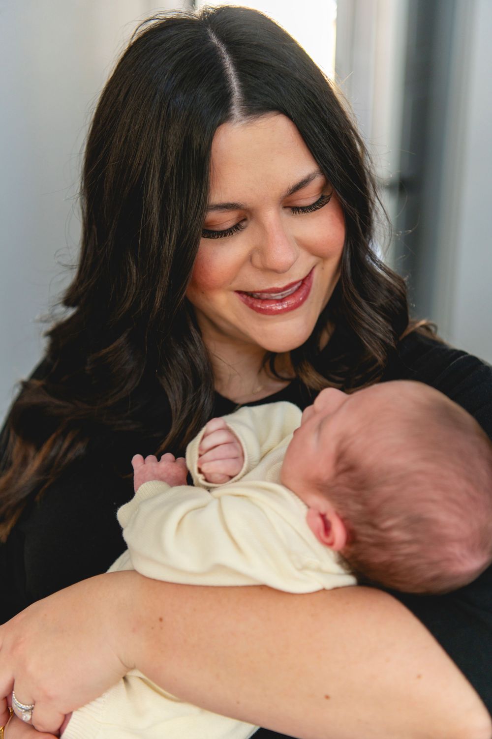 A tender moment between parent and newborn baby in a series of intimate black and white photographs.