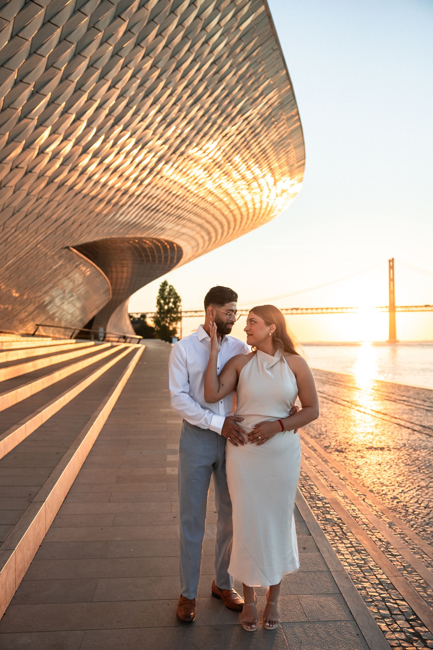 Engagement photo at MAAT Museum Lisbon with couple standing under the modern architectural lines at golden hour