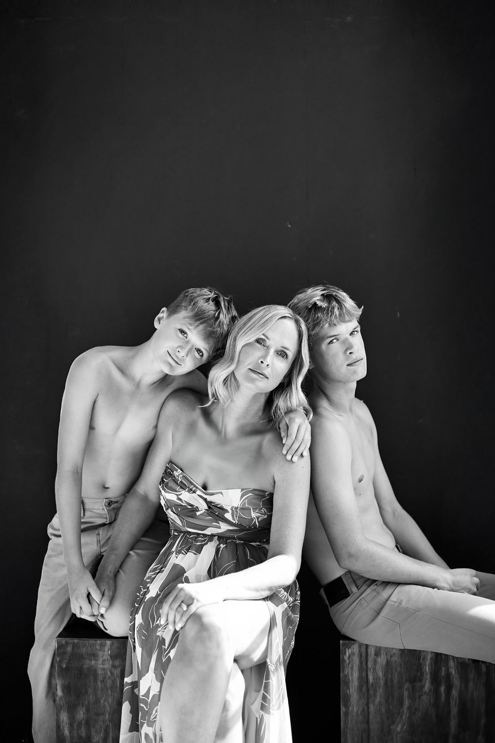 Artistic black and white studio portraits showing intimate poses against dark background.