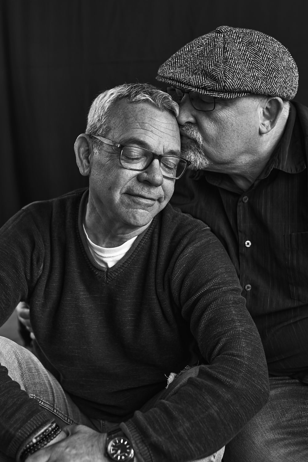 Black and white portraits of two people in casual wear sharing tender moments.