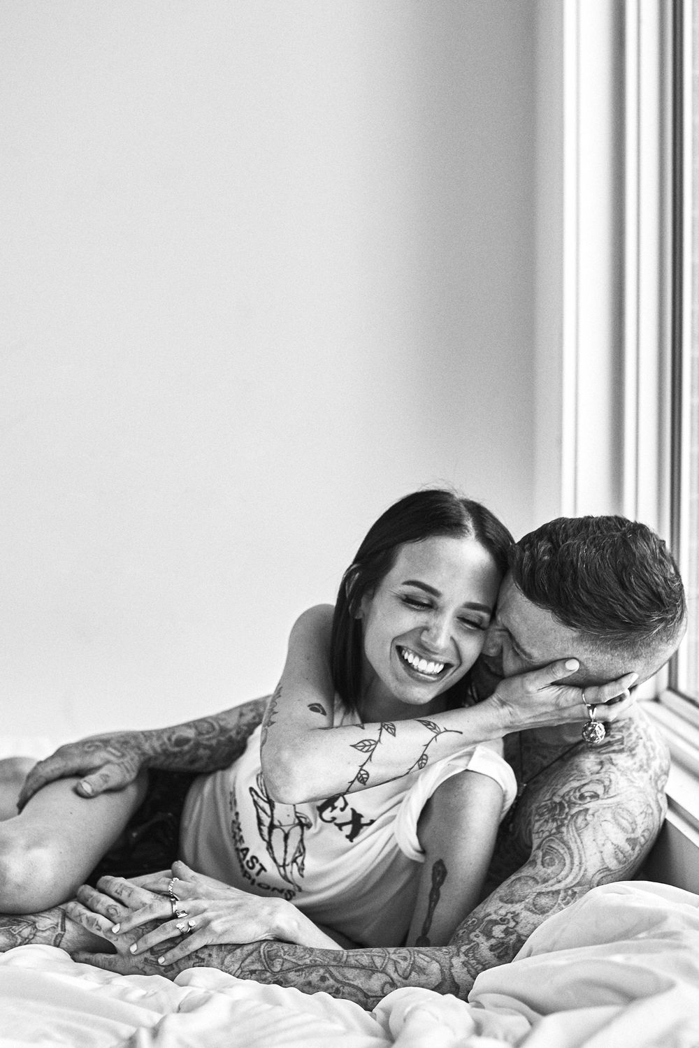 Intimate black and white series showing couple sharing tender moments in bed.