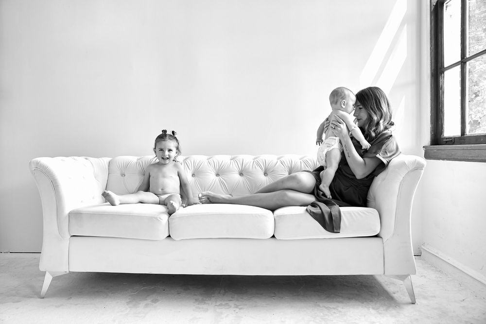 Contemporary lifestyle portraits on white furniture in a minimalist setting.